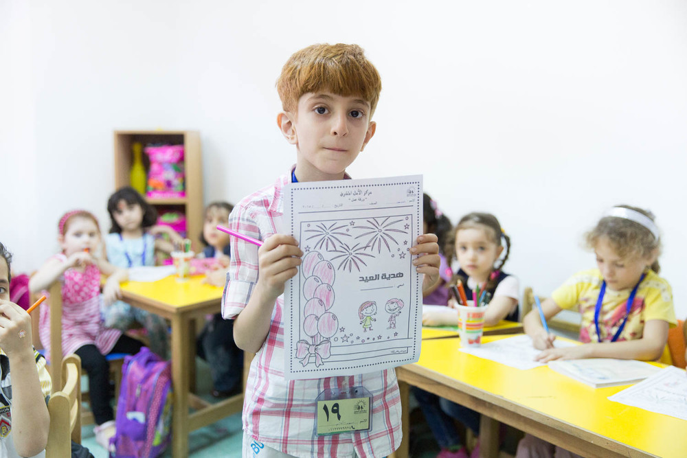 Young children color pictures in the daycare centre run by NGO Ansan.
