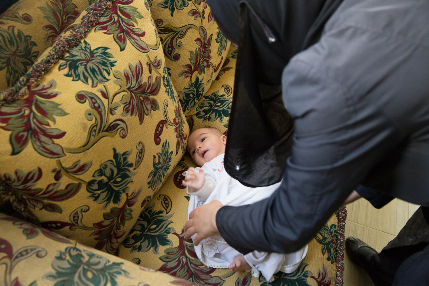  Umm Omar tends to her baby girl in the community center run by NGO Ansan and Plan International. She jokes that her daughter is the only one who belongs here, as she was born in Egypt. 