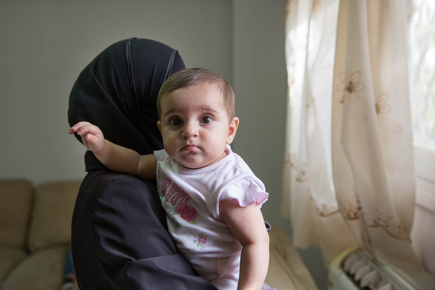  Umm Rawaa holds her youngest daughter. Her family fled to Egypt 3 years ago. Her husband previously worked in customer service in Syria, but partly because of the injury he endured during the war and due to the high unemployment in Egypt, he cannot find work. They are surviving off of financial aid. 