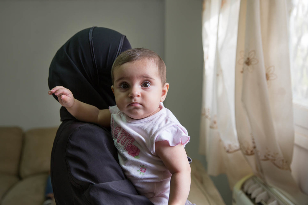 Umm Rawaa holds her youngest daughter. Her family fled to Egypt 3 years ago. Her husband previously worked in customer service in Syria, but partly because of the injury he endured during the war and due to the high unemployment in Egypt, he cannot find work. They are surviving off of financial aid.