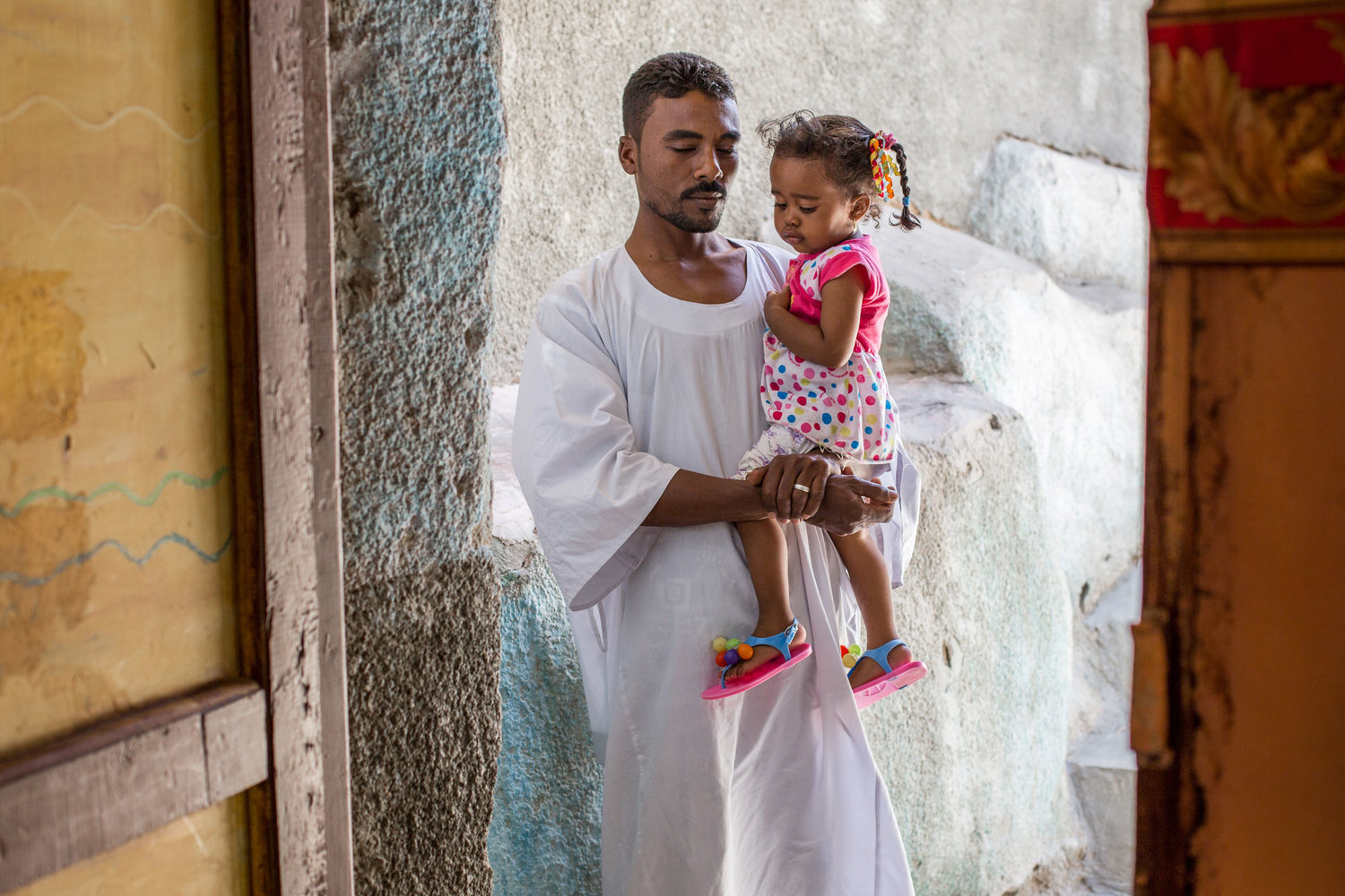  Hares comforts his daughter in their family home on Seheil Island. His name means protector in Arabic. 