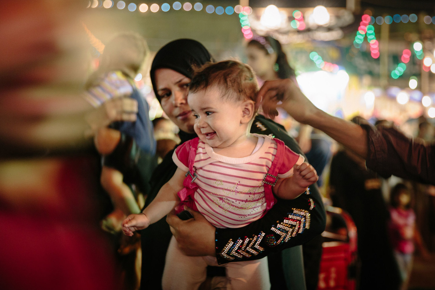  A mother holds her daughter in the crowd. The Sayeda Zeinab moulid draws huge crowds each year, and has gained a reputation for being notorious for harassment and theft. 